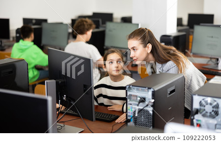 Female teacher helping teen schoolgirl studying in computer lab Female teacher helping teen schoolgirl studying in computer lab 109222053