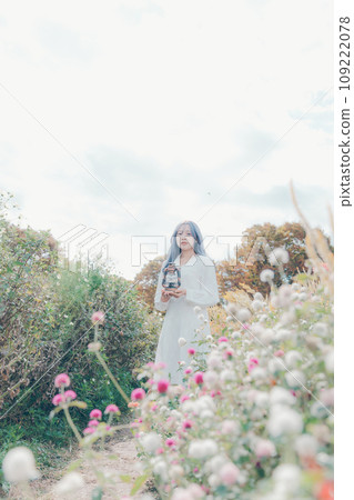 young woman standing in a flower field 109222078