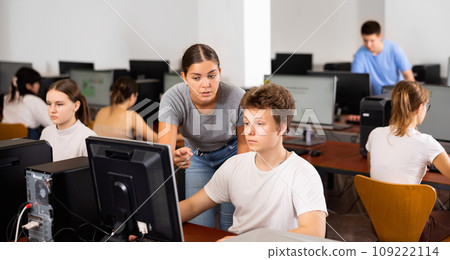 Woman teacher helps guy with learning on computer in school 109222114