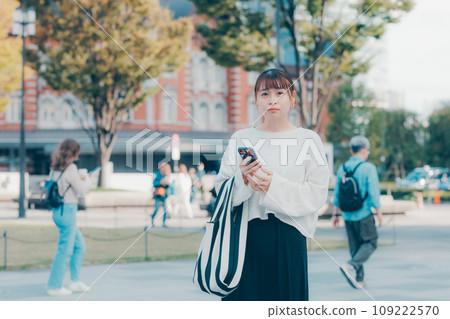 A woman who uses a smartphone in the city 109222570