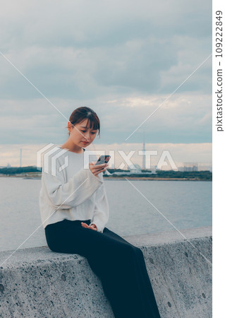 A woman listening to music by the beach 109222849
