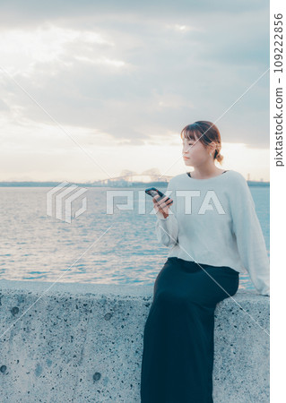 A woman listening to music by the beach 109222856