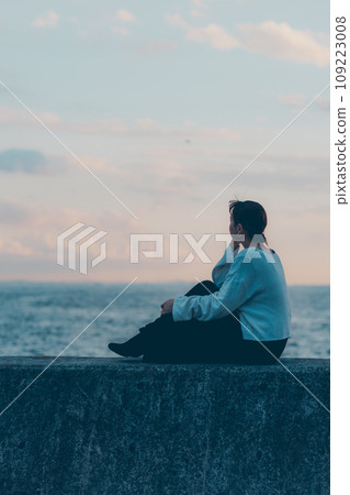 young woman looking at the sea 109223008
