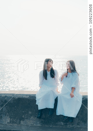 Photo of two young women standing by the seaside Photo of two young women standing by the seaside 109223608