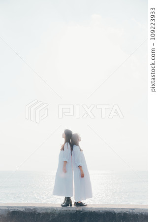 兩名年輕女子背對背站在海灘上的照片 109223933