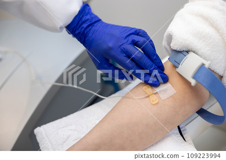 Woman receiving vitamin IV infusion drip in wellness center or beauty salon. 109223994