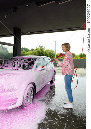 Woman cleaning a white car the car wash 109224097