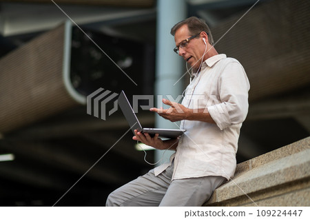Man working online with laptop computer outdoor. 109224447