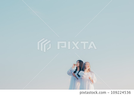 兩個年輕女子在海邊玩肥皂泡 兩個年輕女子在海邊玩肥皂泡 109224536
