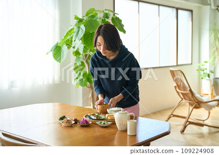 假日早晨，一名婦女在餐桌上提供食物 109224908