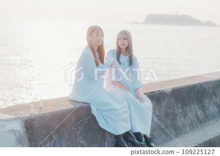 Two young women having a conversation on the beach Two young women having a conversation on the beach 109225127