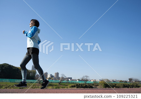 Jogging woman and blue sky 109225321