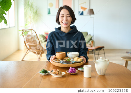 A woman holding a tray with breakfast in her hand 109225358