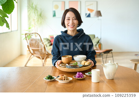一個女人手裡拿著一個托盤，手裡拿著早餐 109225359