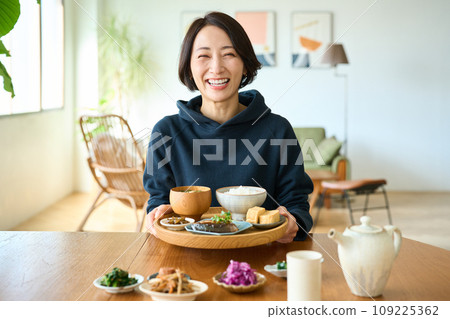 A woman holding a tray with breakfast in her hand 109225362