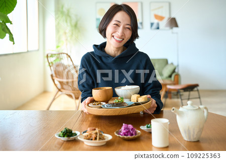 A woman holding a tray with breakfast in her hand 109225363