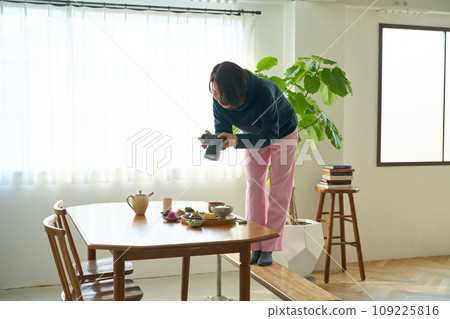 一位女士用相機拍攝食物 一位女士用相機拍攝食物 109225816