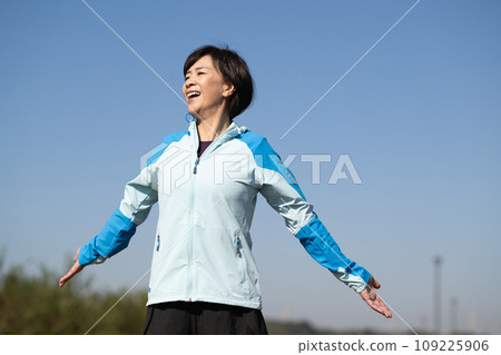 Healthy woman stretching and warming up outside 109225906