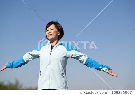 Healthy woman stretching and warming up outside 109225907