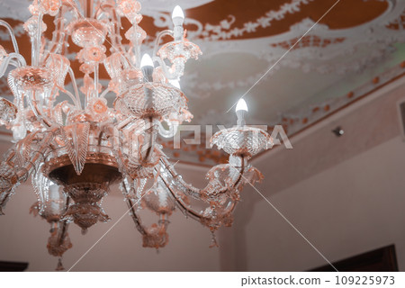 A stunning pink glass chandelier hangs in a neutral-toned room, creating a striking focal point. The elegant design adds a touch of glamour to any space. A stunning pink glass chandelier hangs in a neutral-toned room, creating a striking focal point. The elegant design adds a touch of glamour to any space. 109225973