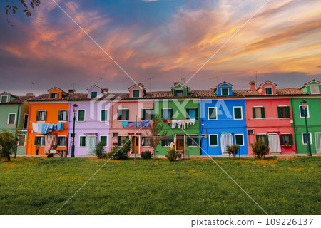 Vibrant and charming, this picturesque scene showcases a row of colorful houses on the island of Burano in Venice, Italy. The traditional architecture adds to the overall appeal of the scene. 109226137