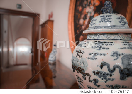 A white and blue jar sits on a wooden table in this image from Venice, Italy. The contents of the jar are not specified. 109226347