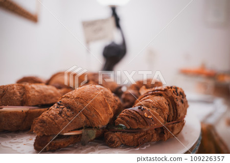 Freshly baked croissants on a plate in a cozy bakery in Venice, Italy. The inviting atmosphere and delicious pastries make this a must-visit spot for travelers. Freshly baked croissants on a plate in a cozy bakery in Venice, Italy. The inviting atmosphere and delicious pastries make this a must-visit spot for travelers. 109226357