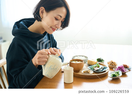 一個女人在茶壺裡倒茶 109226559