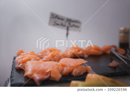 A simple and straightforward presentation of a plate of salmon and other food. The salmon is arranged in the center of the plate, creating an appealing visual composition. 109226596