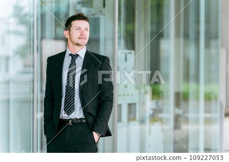Foreign businessman (white male, foreign company, investor) standing in front of a building 109227053