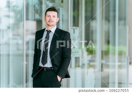 Western businessman standing in front of a building, overseas business trip, overseas assignment, trading company, trade Western businessman standing in front of a building, overseas business trip, overseas assignment, trading company, trade 109227055