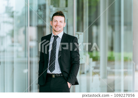 Foreign businessman (trade, foreign capital, white male) standing in front of a building Foreign businessman (trade, foreign capital, white male) standing in front of a building 109227056