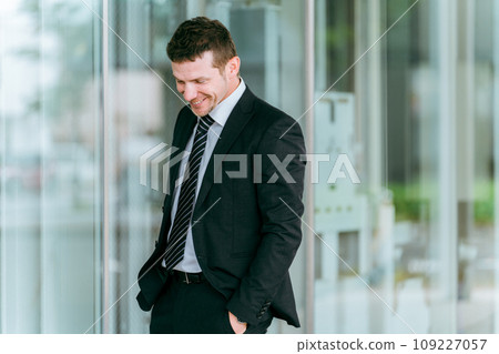 Foreign businessman (white male) standing in front of a building 109227057