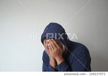 sad man in hood cover face with hands . sad man in hood cover face with hands . 109227071