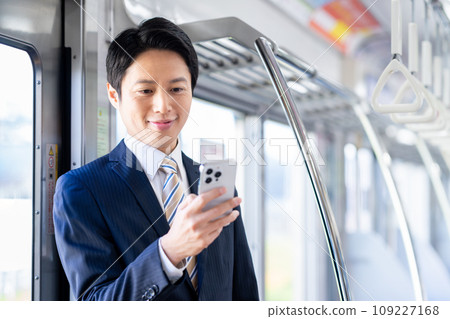 Businessman on a commuter train Photography cooperation: Keio Electric Railway Co., Ltd. Businessman on a commuter train Photography cooperation: Keio Electric Railway Co., Ltd. 109227168