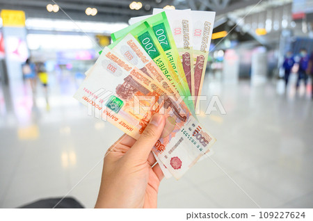 Close-up of someone holding and showing variety of Russian banknotes in the hand. The Russian ruble is the currency of the Russian Federation. Close-up of someone holding and showing variety of Russian banknotes in the hand. The Russian ruble is the currency of the Russian Federation. 109227624