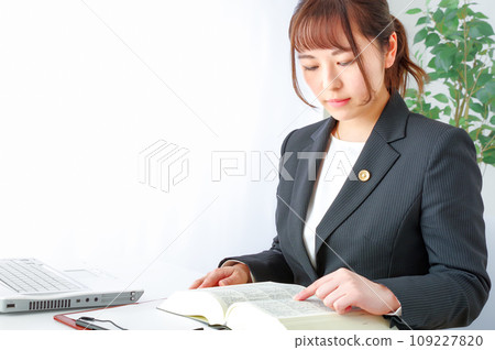 Female lawyer reading a law book Female lawyer reading a law book 109227820