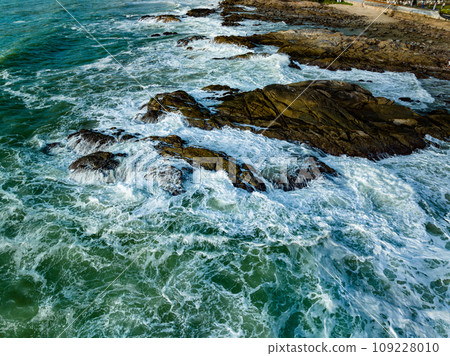 Bird eye view seashore with big wave crashing on rock cliff. Beautiful waves sea surface in sunny day summer background, Amazing seascape top view seacoast landscape view 109228010