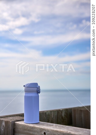淺藍色水瓶放在木柱上,背景是海 淺藍色水瓶放在木柱上,背景是海 109228207