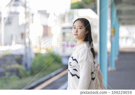 Young woman waiting for the train on the platform. Photography provided by Keio Electric Railway Co., Ltd. 109229059
