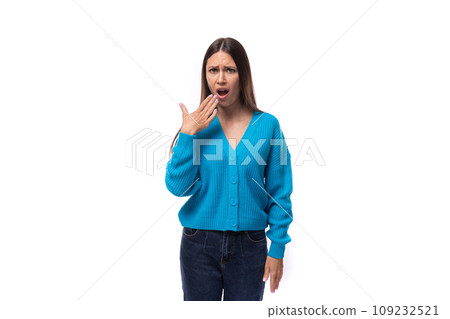 young well-groomed brunette woman dressed in a blue cardigan yawns on a white background with copy young well-groomed brunette woman dressed in a blue cardigan yawns on a white background with copy 109232521