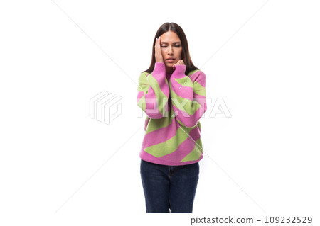 young slender caucasian woman with straight black hair dressed in a striped pink pullover posing on young slender caucasian woman with straight black hair dressed in a striped pink pullover posing on 109232529