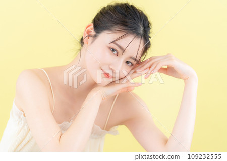 Young woman doing skin care with yellow back 109232555