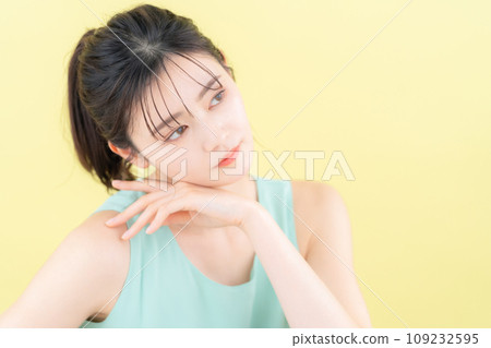Young woman doing skin care with yellow back 109232595
