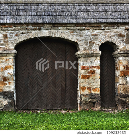 Old wooden gate in the stone wall of the fortification 109232685