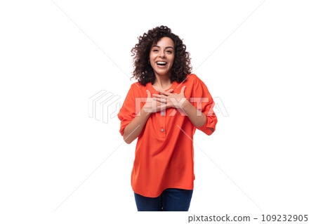 young curly brunette woman dressed in an orange blouse on a white background young curly brunette woman dressed in an orange blouse on a white background 109232905