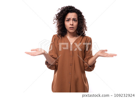 young secretary brunette woman dressed in a brown shirt stands thoughtfully on a white background 109232924