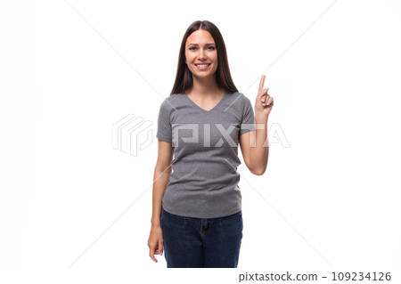young funny cheerful caucasian woman with dark straight hair dressed in casual gray t-shirt young funny cheerful caucasian woman with dark straight hair dressed in casual gray t-shirt 109234126