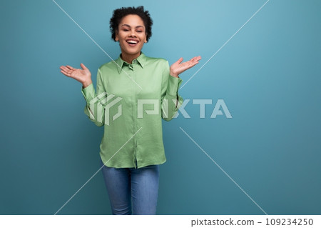 young bright cheerful latin woman dressed in a green blouse on the background with copy space young bright cheerful latin woman dressed in a green blouse on the background with copy space 109234250