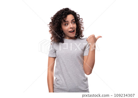 charming curly brunette promoter woman dressed in gray t-shirt with mockup for print on white 109234307